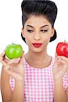 Thoughtful black hair model holding apples on white background