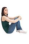 Pensive attractive brunette sitting on white background