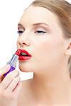 Glamorous blonde applying red lipstick on white background