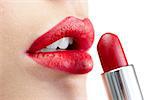 Extreme close up on model on white background applying red lipstick