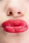 Extreme close up on gorgeous voluminous red lips kissing at camera