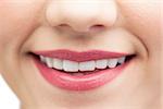 Extreme close up on beautiful white smile wearing pink lipstick