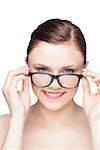 Happy natural model looking over her classy glasses on white background