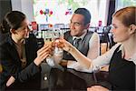 Young business people celebrating a success with champagne in restaurant