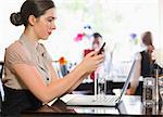 Businesswoman texting on phone in a restaurant