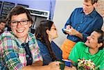 Happy young woman with eyeglasses in cafe with friends