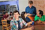 Grinning woman with friends in coffee house