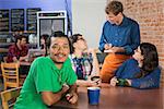 Smiling Indian man with Caucasian friends in cafe