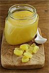 Homemade lemon curd in glass jar on a wooden table