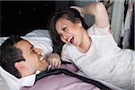 Close-up of couple laying on bed laughing