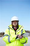 Portrait of female outdoors holding file and digital tablet