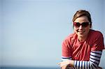 Portrait of young woman wearing heart shape sunglasses at coast