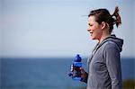 Young woman at coast taking exercise break