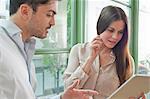 Young office workers looking at digital tablet