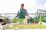 Portrait of organic farmer with trays of seedlings