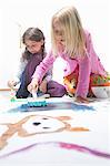 Two girls painting on floor