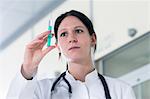 Portrait of female doctor holding up syringe