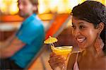 Close up of young woman holding cocktail at indoor beach party