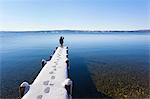 Boy standing on snow covered pier, Lake Starnberg, Bavaria, Germany