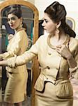 Woman in vintage clothes looking in mirror