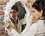 Woman in vintage clothes holding mirror