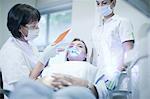 Dentist applying ultraviolet light to patients teeth