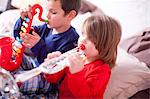 Two young children playing toy instruments