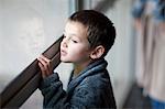 Young boy watching through porch window