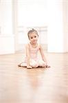 Portrait of young ballerina sitting on floor