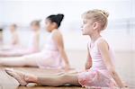 Young ballerinas sitting on floor in pose