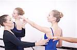 Teacher adjusting teenage ballerinas arm pose