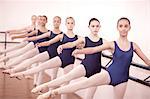 Row of teenage ballerinas with legs outstretched