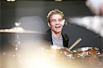 Young male playing drum kit in music store