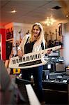 Young woman playing keytar in music store