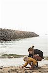 Mother and toddler exploring shoreline