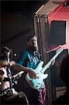 Men playing guitars on stage in club