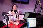 Mid adult woman broadcasting in recording studio, portrait