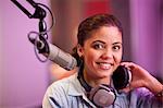 Young woman broadcasting in recording studio, portrait