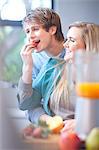 Young couple eating fruit and preparing juice drink