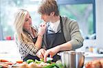 Affectionate young couple preparing food