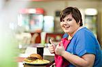 Young woman in cafe with unhealthy meal