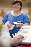 Young woman paying for takeaway order in cafe