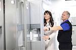 Woman looking at refrigerators in showroom