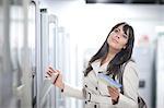 Woman daydreaming whilst shopping in showroom