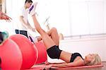 Young woman on gym floor training with exercise balls