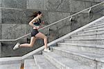 Young woman running up stairway