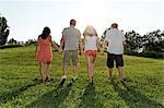 Group of young adults walking and holding hands