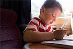 Close up of young boy with puzzle book on train