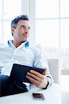 Man sitting on sofa using digital tablet