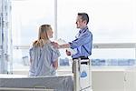 Doctor talking to patient sitting on hospital bed